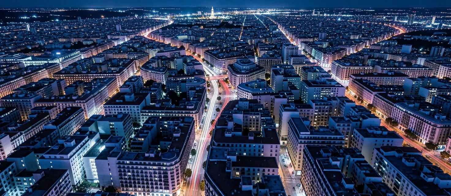 Vista aérea nocturna de una retícula urbana con estelas de luz
